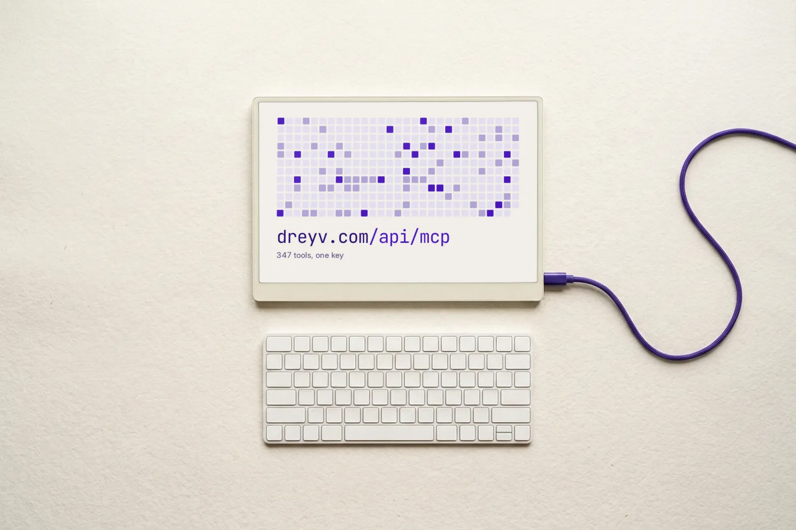 A tablet with a white keyboard and a violet cable. The screen shows a grid of violet squares above dreyv.com/api/mcp and 347 tools, one key.