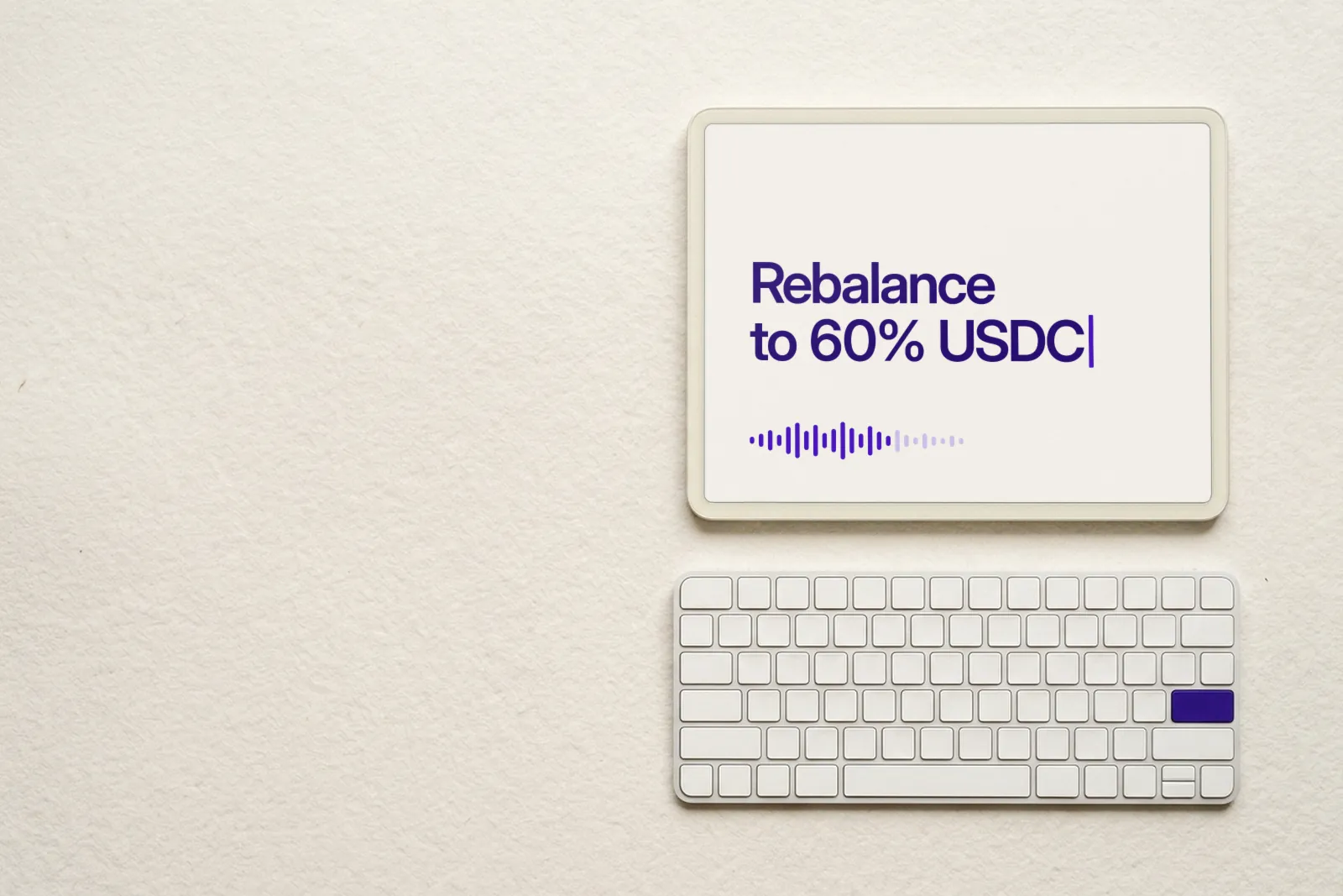 A tablet above a white keyboard on cotton paper. The screen shows the sentence Rebalance to 60% USDC with a blinking cursor and a small voice waveform.